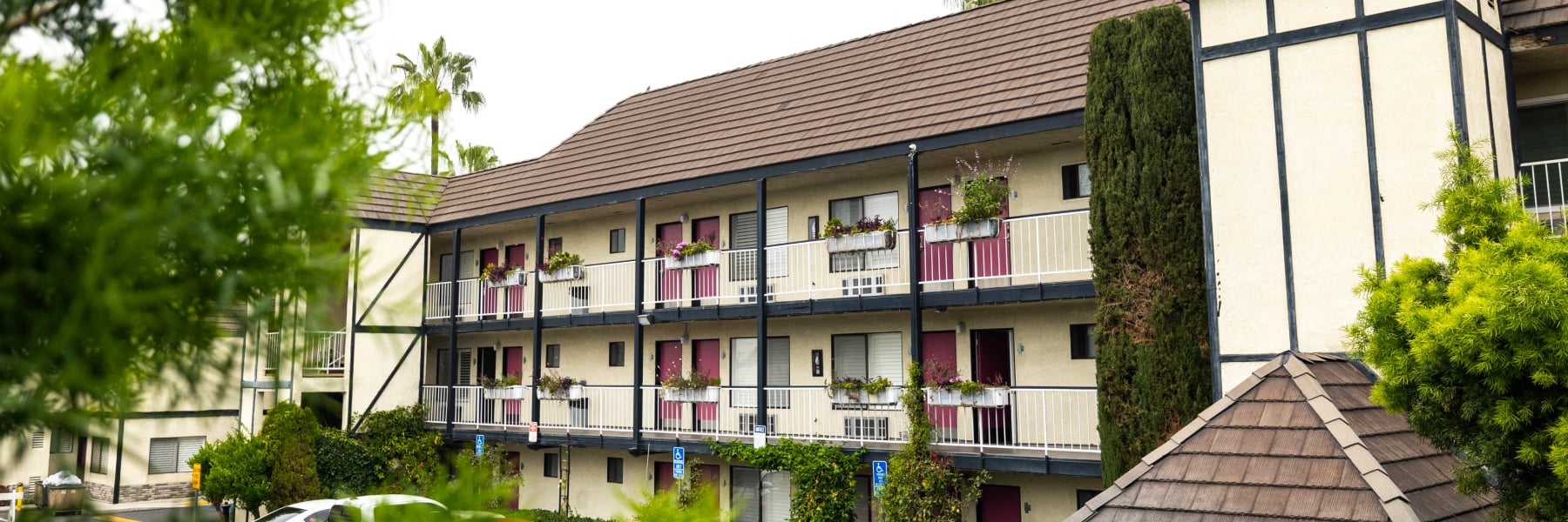 A three-story building with balconies and a brown roof